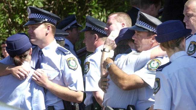 Police comfort their colleagues at the funeral of Detective Inspector Ken Henderson in Newcastle in 2001. Picture Robert McKell.jpg